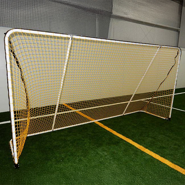 A Folding Aluminum Soccer Goal with a yellow net is set up on indoor artificial turf, positioned along a yellow line inside a sports facility.