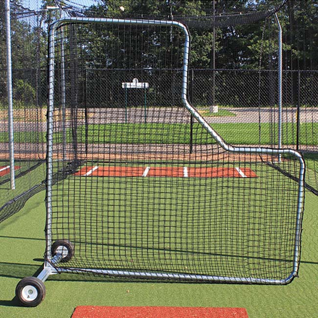 The 7 x 7 Pitchers L Screen, featuring a Gatorshield® steel frame and UV-treated nylon netting, stands on artificial turf in a batting cage, with red batter’s boxes and a fence seen in the background.