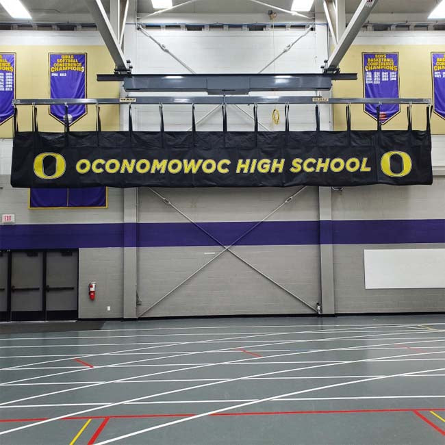 Branded mat hoist in high school gym.