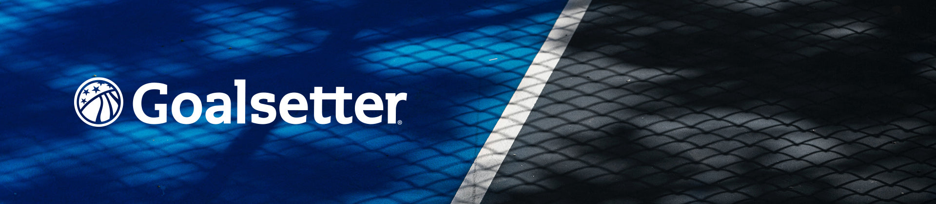 A blue outdoor sports court with a white line, overlaid with chain-link fence shadows. The word Goalsetter and a logo featuring a basketball and star are displayed on the left side.