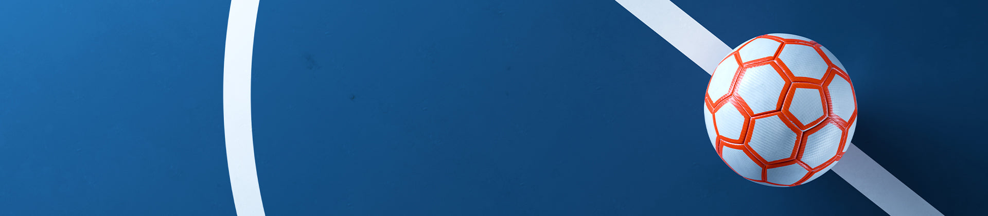 A white futsal ball with orange patterns rests on a blue court, near intersecting white boundary lines.