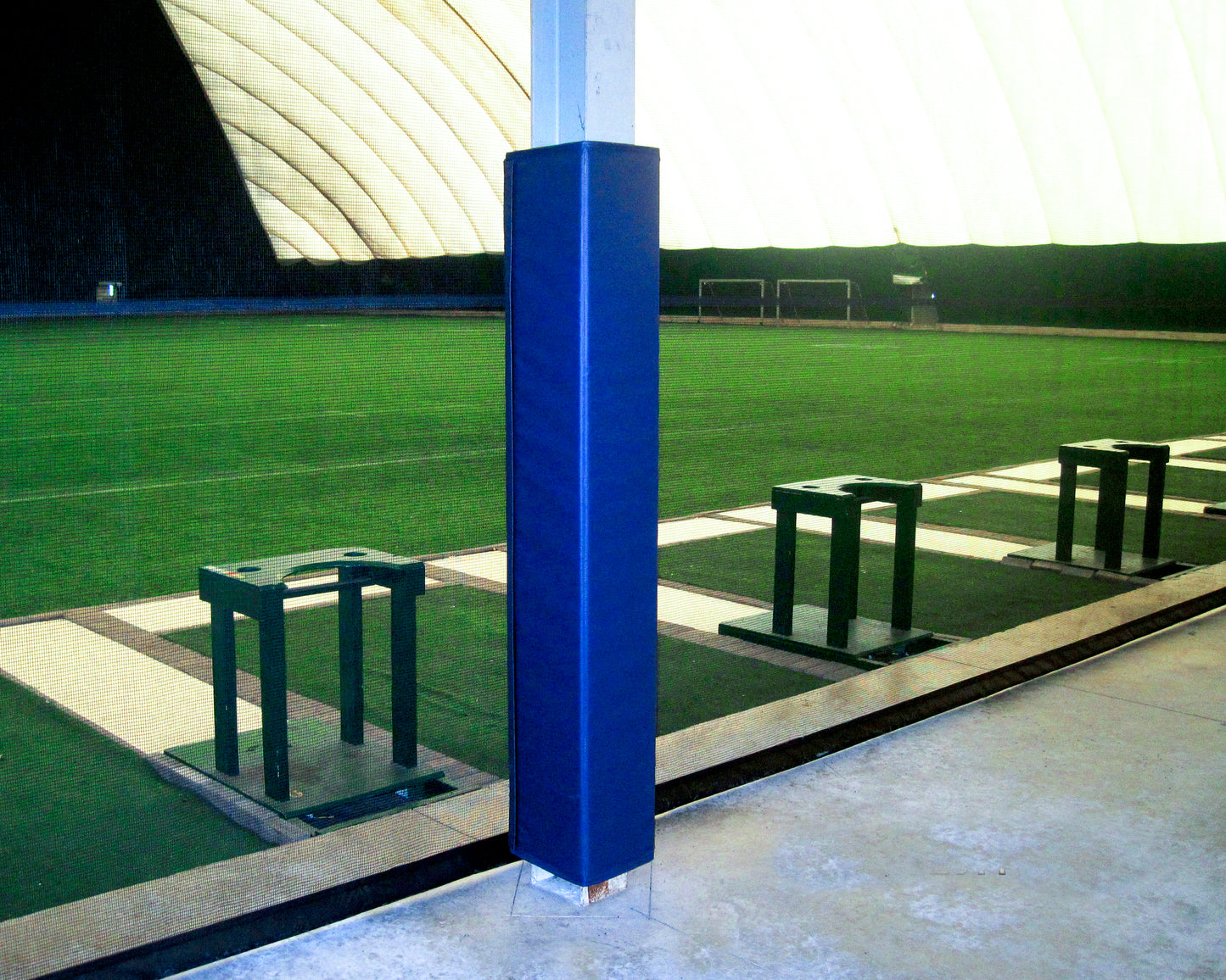 Four sided padding on metal beam at indoor soccer facility.