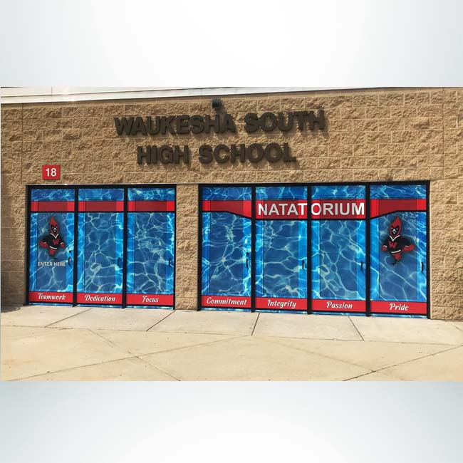 Entrance to school shown after school branding combination perforated window film and door wrap is installed.