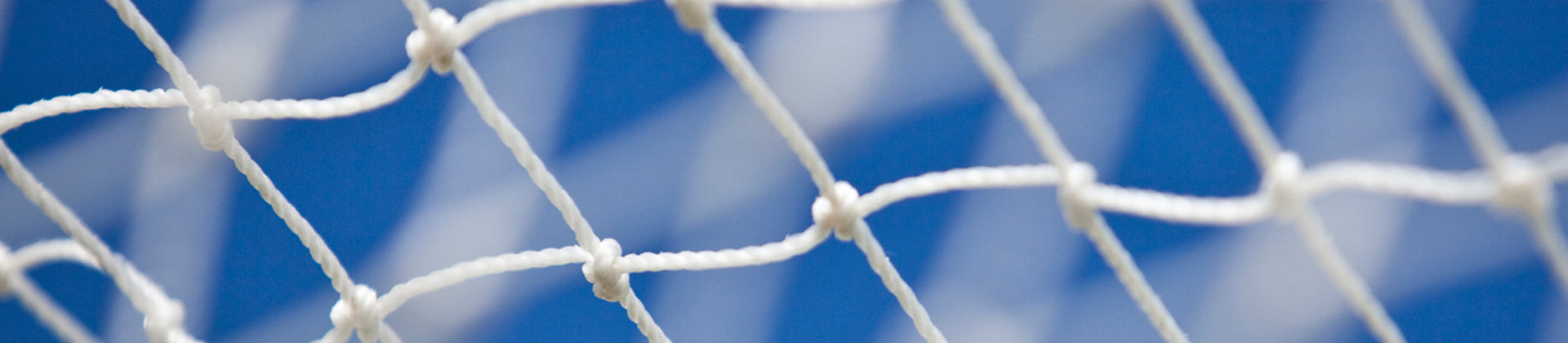 A close-up view of a white net with square holes against a blurred blue background, possibly the sky. The nets texture and knots are clearly visible.