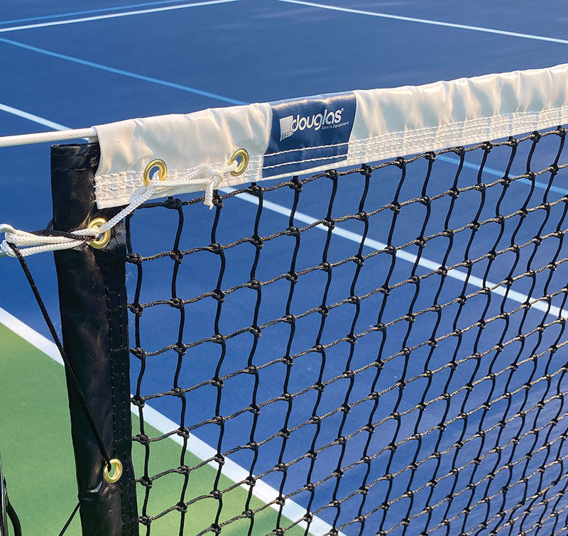 Close-up of a black TN-36T Tapered Tennis Net with a white band displaying the douglas brand, set up on a blue and green tennis court with crisp white lines.