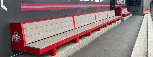 Custom baseball dugout furnishings installed in a collegiate baseball dugout, featuring durable composite seating and team-branded construction.