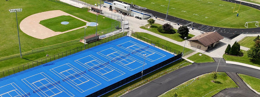Athletic facility upgrades at Howards Grove High School featuring tennis courts, football bleachers, baseball field, and sports equipment installed by Keeper Goals