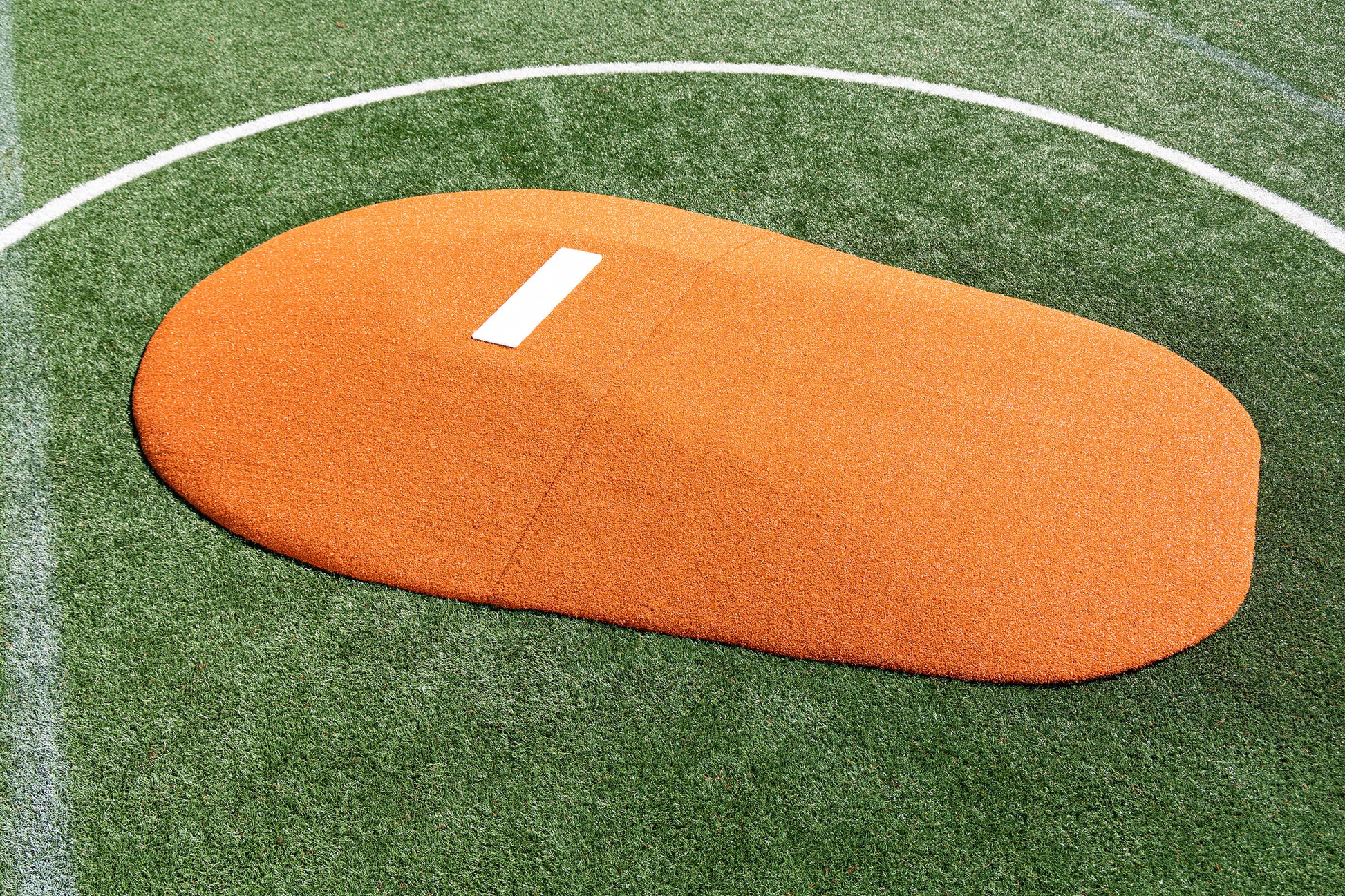 A Portolite 10″ Two-Piece Game Mound | Portable Pitching Mounds with a white pitching rubber is set on green turf bordered by white lines.