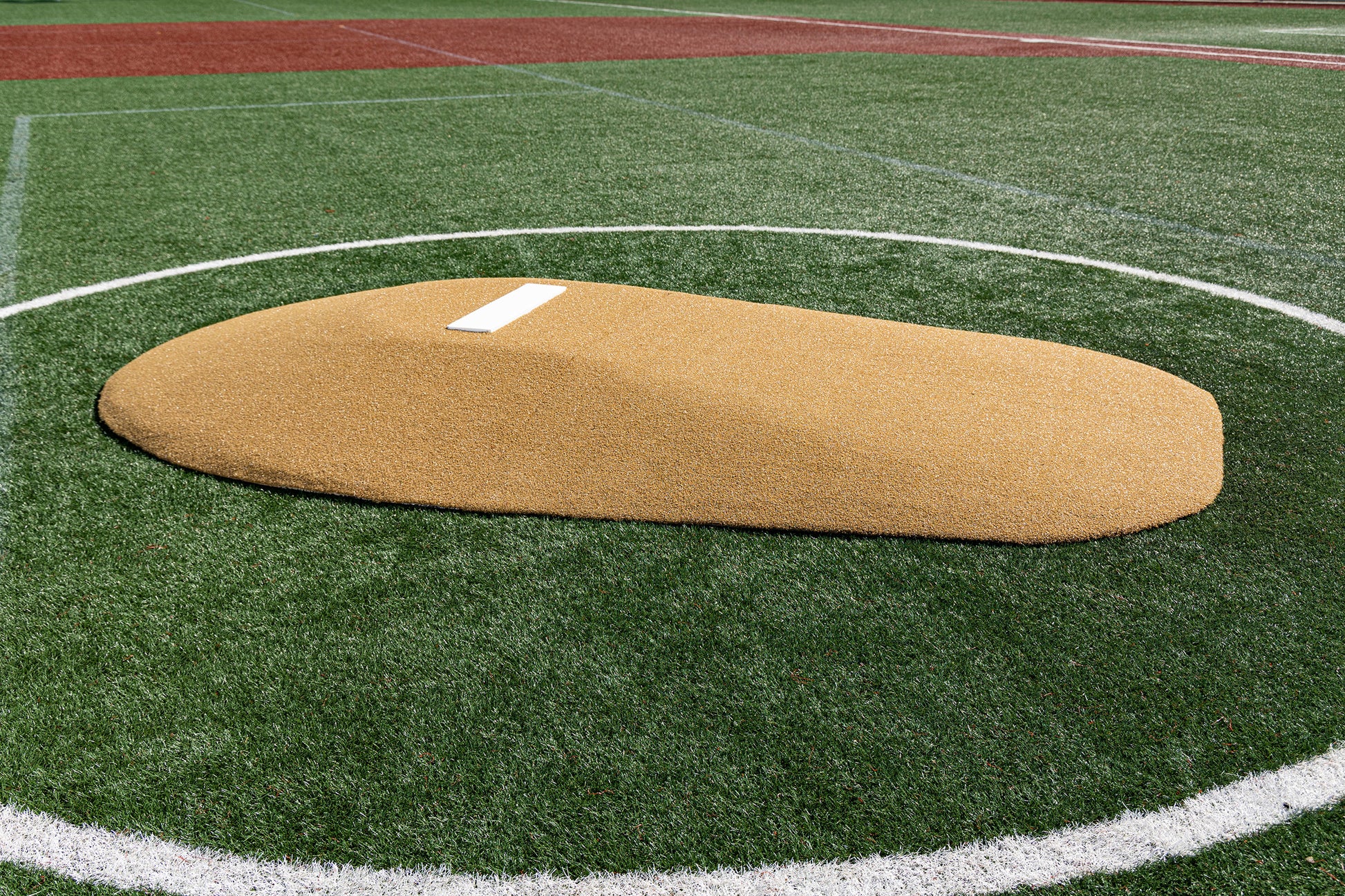The Portolite 10″ Two-Piece Game Mound | Portable Pitching Mounds, featuring a durable poly core and a white pitching rubber, is set on artificial turf within a white chalk circle on the baseball field, providing the authentic appearance of an AstroTurf mound—perfect for both training and games.