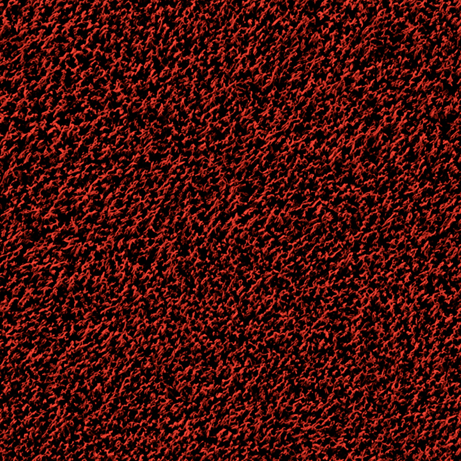 A close-up view of a textured surface with a dense pattern of red and black, creating a rough, almost fuzzy appearance. The interwoven colors add depth and intricate detail, reminiscent of the durable weave found in the Portolite Pitching Mound Protector | 13′ x 4′ Inlaid Pitching Mound Mat designed for turf protection.