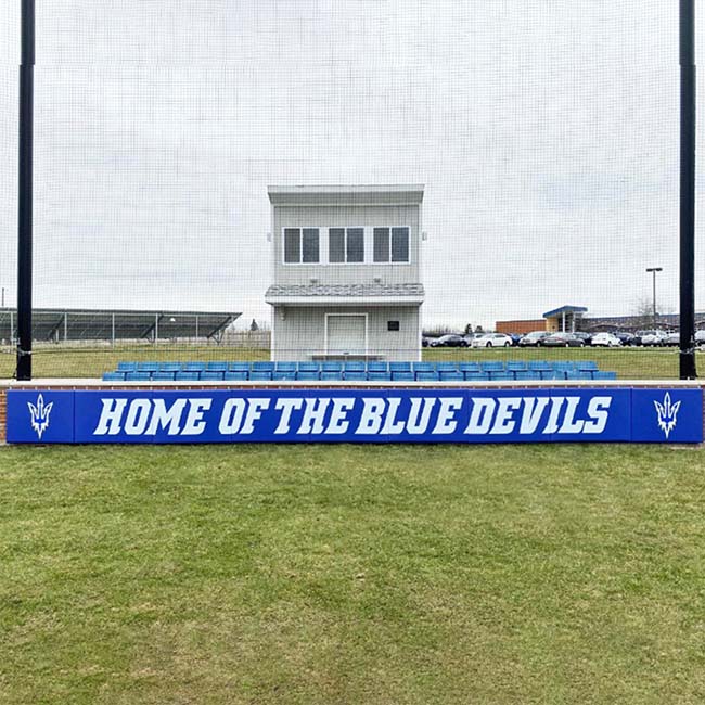 Royal blue wall padding with white lettering and logos.