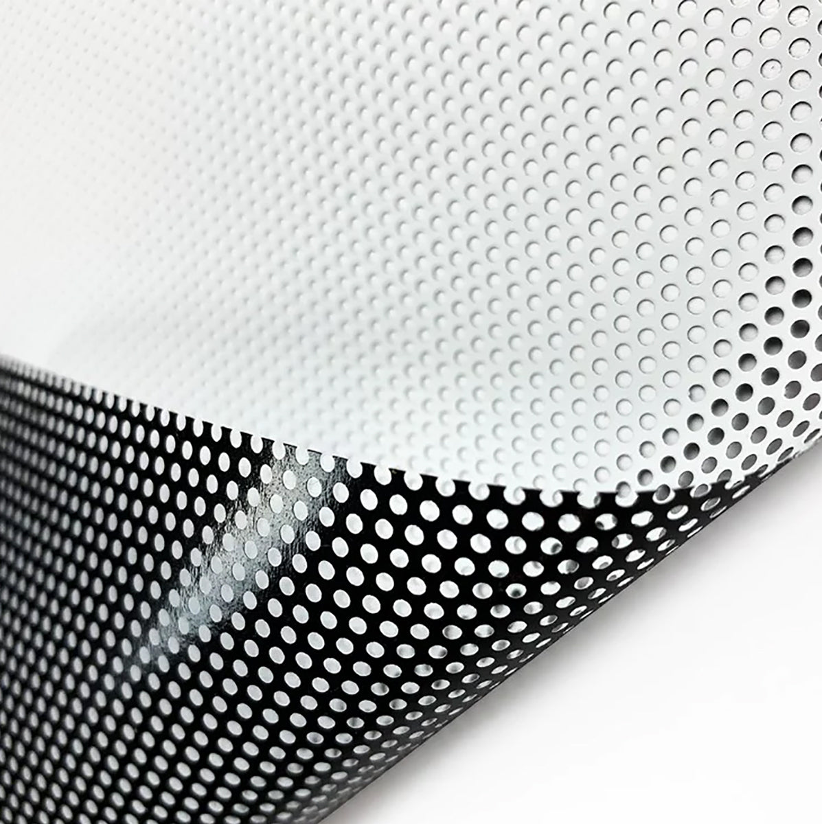 A close-up of Perforated Window Film shows small round holes, a white top layer, and black underside for a dotted look. The slightly curled sheet is ideal for custom window graphics.