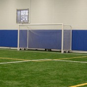 Wheeled soccer goal at indoor athletic facility.