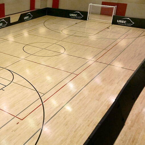 Model #FSP44. Protective boundary padding with custom logos for indoor soccer field on basketball court.