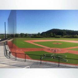 Custom engineered tieback baseball netting at a high school baseball stadium.