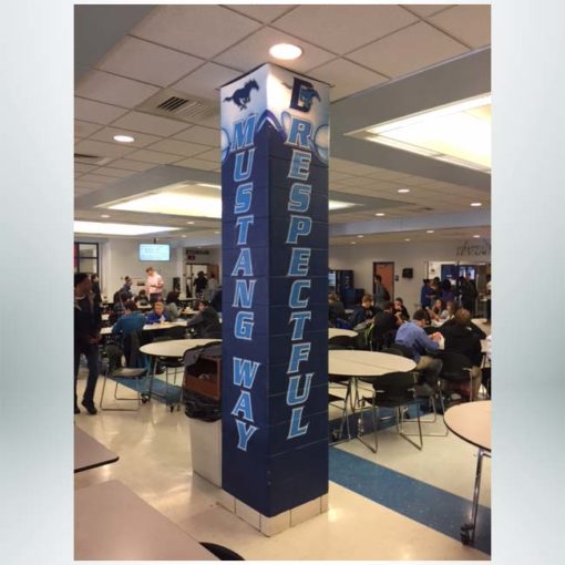 Concrete pillar wraps in blue, red and white with school logo.