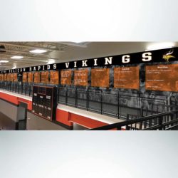 School branding wall wrap in gymnasium with black and white graphics and athletic championships.