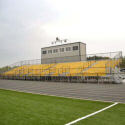 Elevated bleachers with yellow risers and press box.