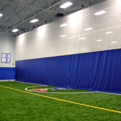 Divider curtain in custom blue and white. Custom fold up curtain to separate indoor soccer fieldw.