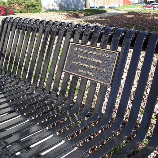 Memorial park bench with commemorative plaque close up