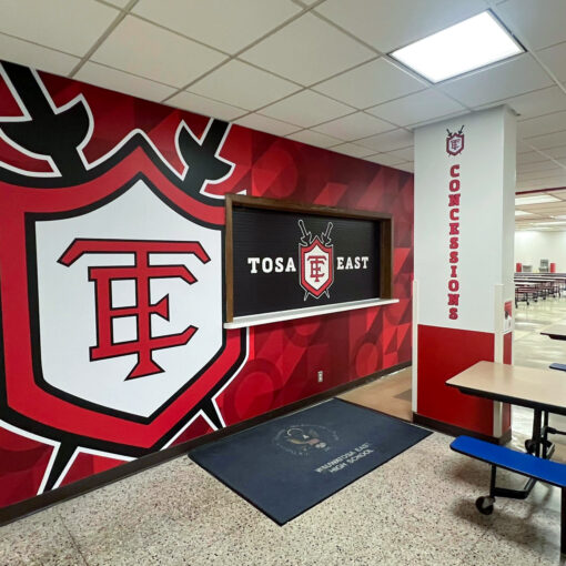 Tosa East graphics on concession stand door. Red, white and black logo and graphics.