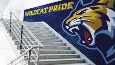 Blue vinyl graphic in front of stairwell with wildcat pride written in yellow and a wildcat.