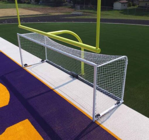 Front view from above of custom box soccer goal in white in front of football goal on field.